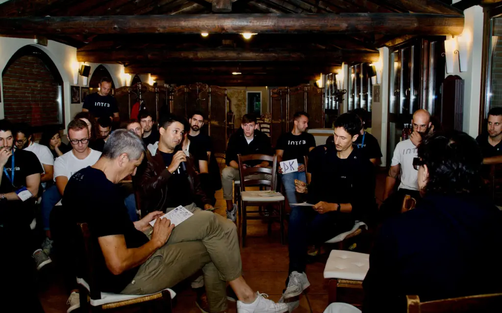 Persone intente a discutere sedute durante il fishbowl, e persone sedute intorno. Intré Camp settembre 2025