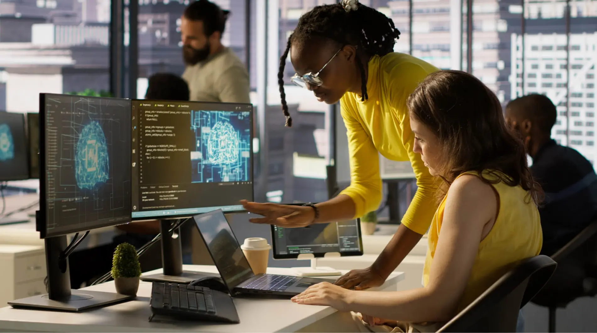 Two people look at a monitor displaying machine learning stuff.